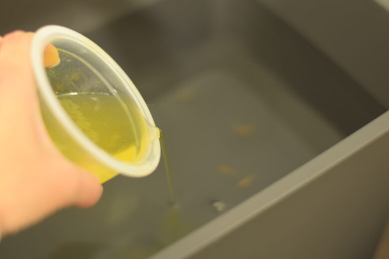 濃縮したグリーンFゴールド顆粒の薬を赤斑病のメダカのみを隔離している容器へ入れているところ